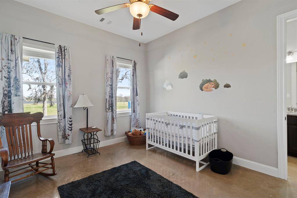 Two expansive windows in this secondary bedroom offer scenic views of the property.