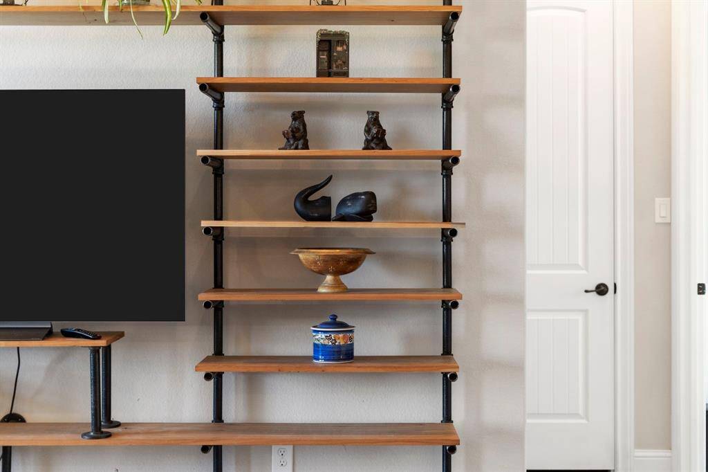 An industrial-style built-in bookshelf serves as a striking architectural centerpiece in the living room.