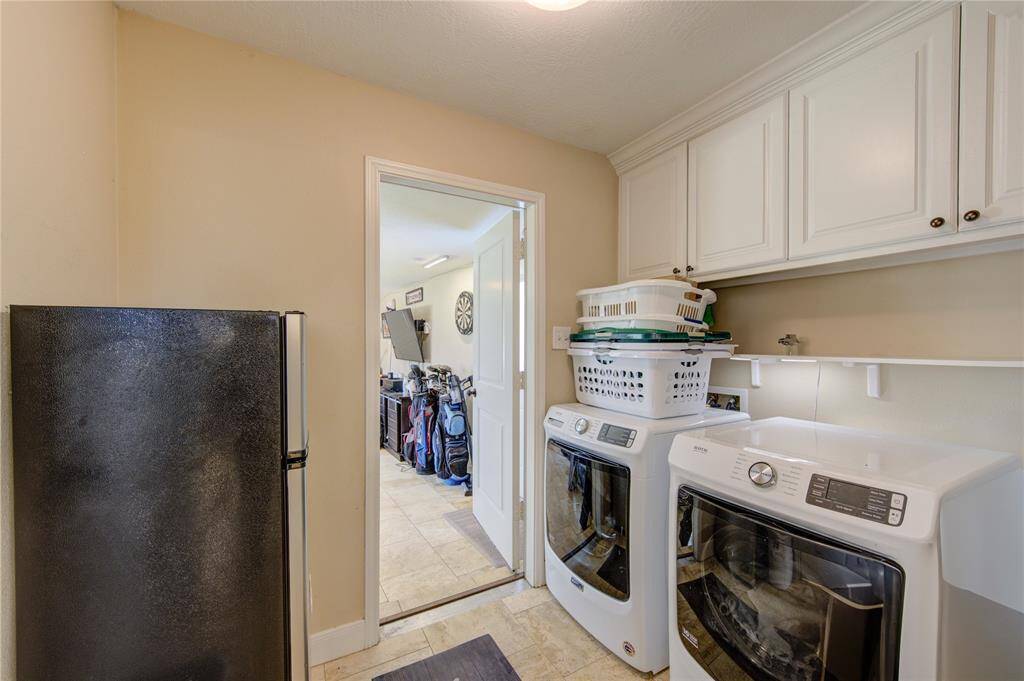 Laundry room with space for a second fridge.