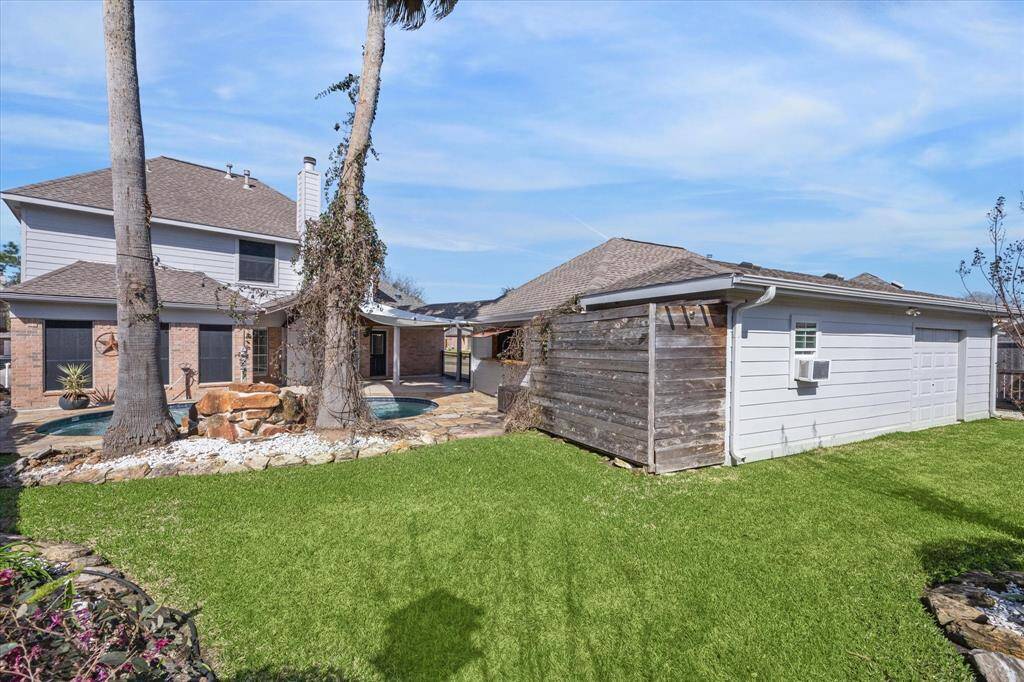 Great grassy area behind pool and garage (check out the extra garage door on the back of the garage!)