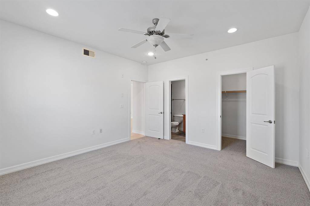 The primary bedroom features plush carpet, ceiling fan, recessed lighting, and large window.
