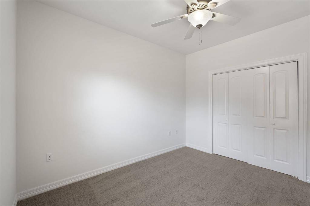 The walk-in closet has built-in shelving with plenty of storage space.