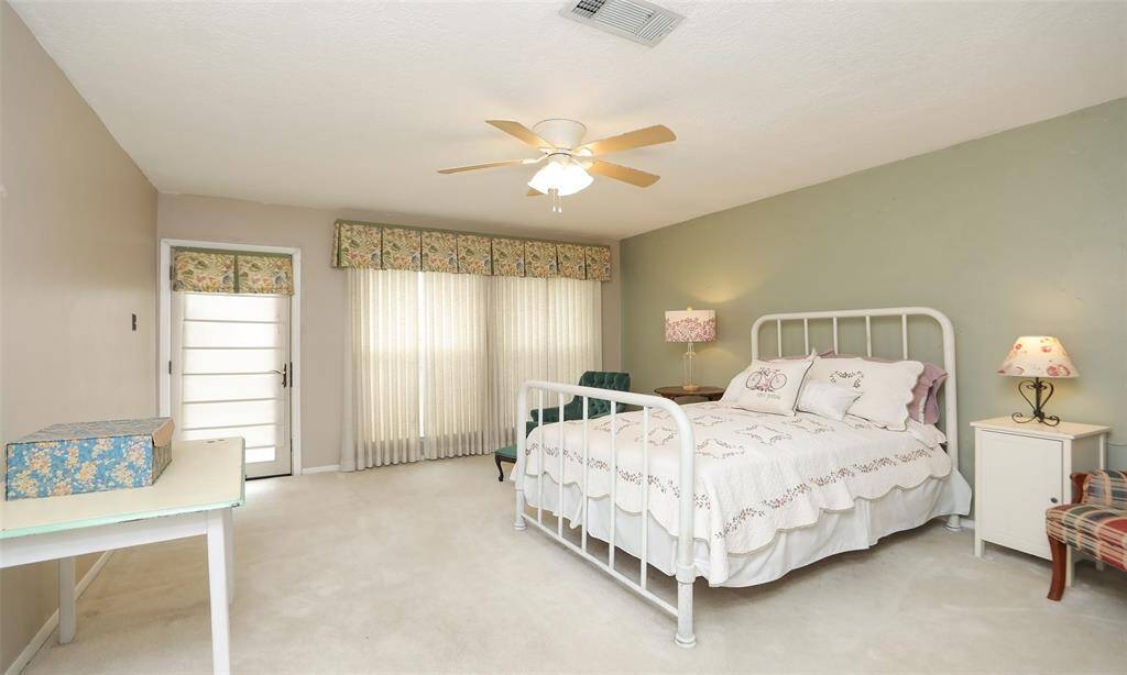 The Primary bedroom is roomy with lots of windows and door that leads to the bakyarad.