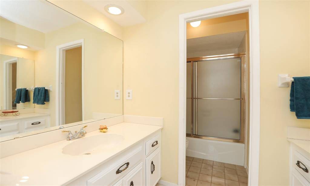 This secondary bathroom has a separate room for the bath tub shower combo and toilet from the dual vanities.