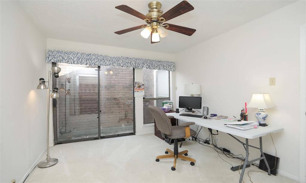 Lovely secondary bedroom has sliding doors that lead to an atrium area. Also has built in shelves in closet for storage.