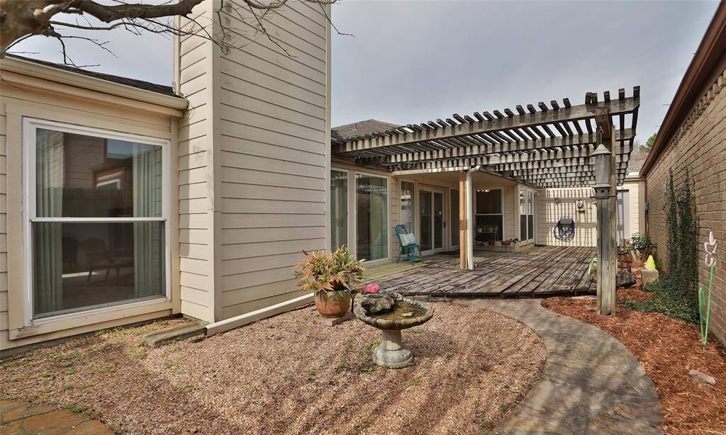 View of the well landscaped backyard and deck