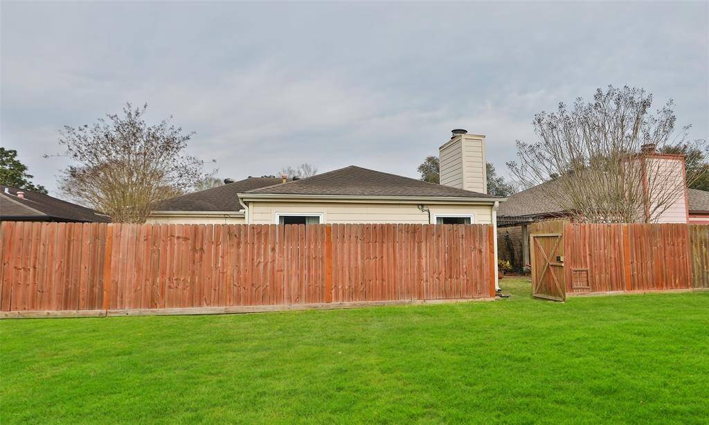 Gate from the backyard opens out onto a grassy area and leads to the greenbelt.