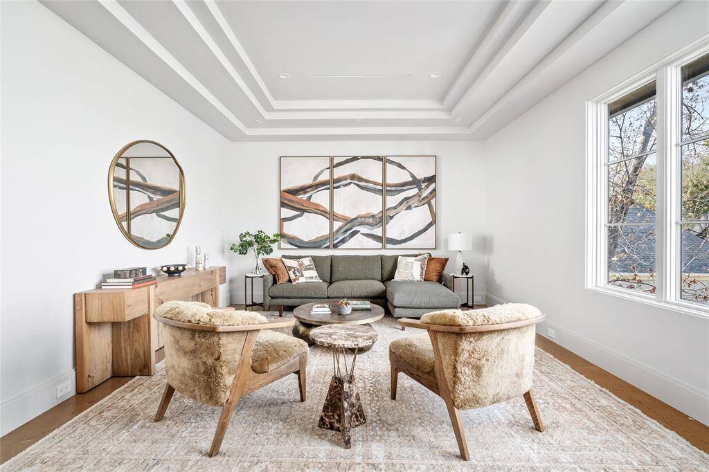 Expansive and versatile, this upstairs den offers ample space for entertainment and relaxation. A step-down tray ceiling adds dimension and elegance, while large windows flood the room with natural light, providing scenic views and enhancing the open and airy feel.