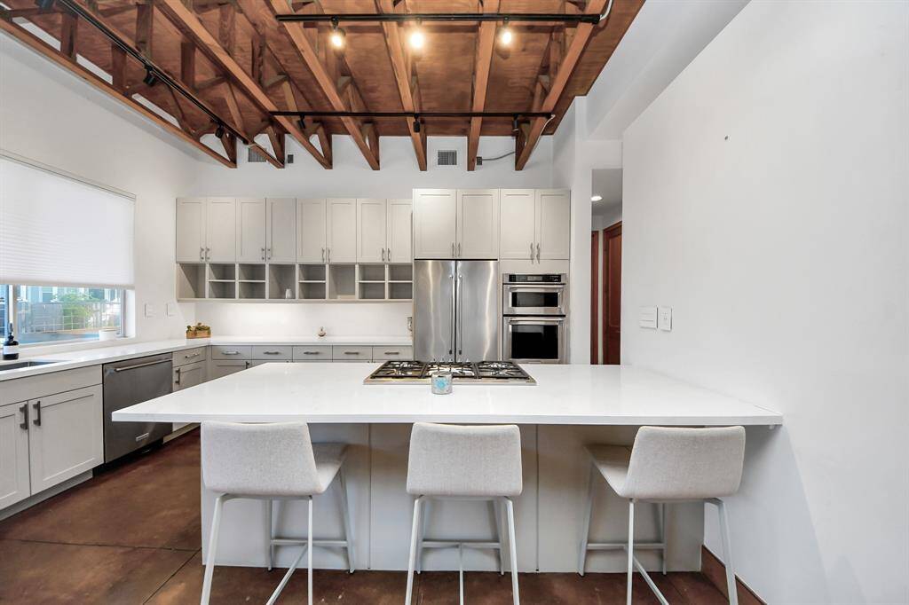 Kitchen with breakfast bar and a retractable vent for use while cooking on gas stove.