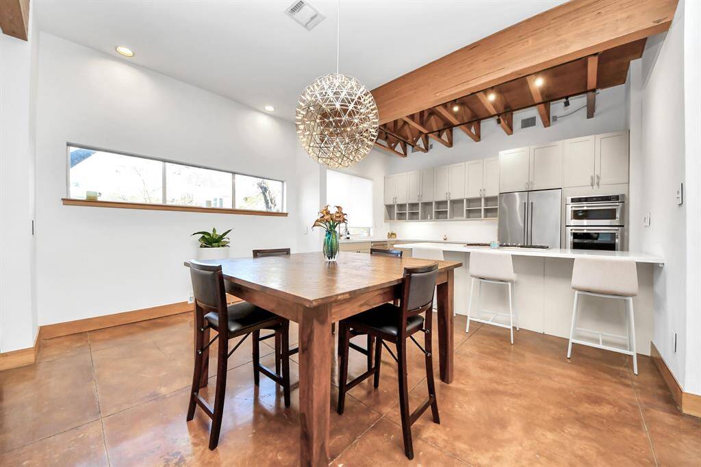 Large dining area is located between the open Living space and Kitchen.  Breakfast bar with built in gas cook top has a retractable vent for use while cooking