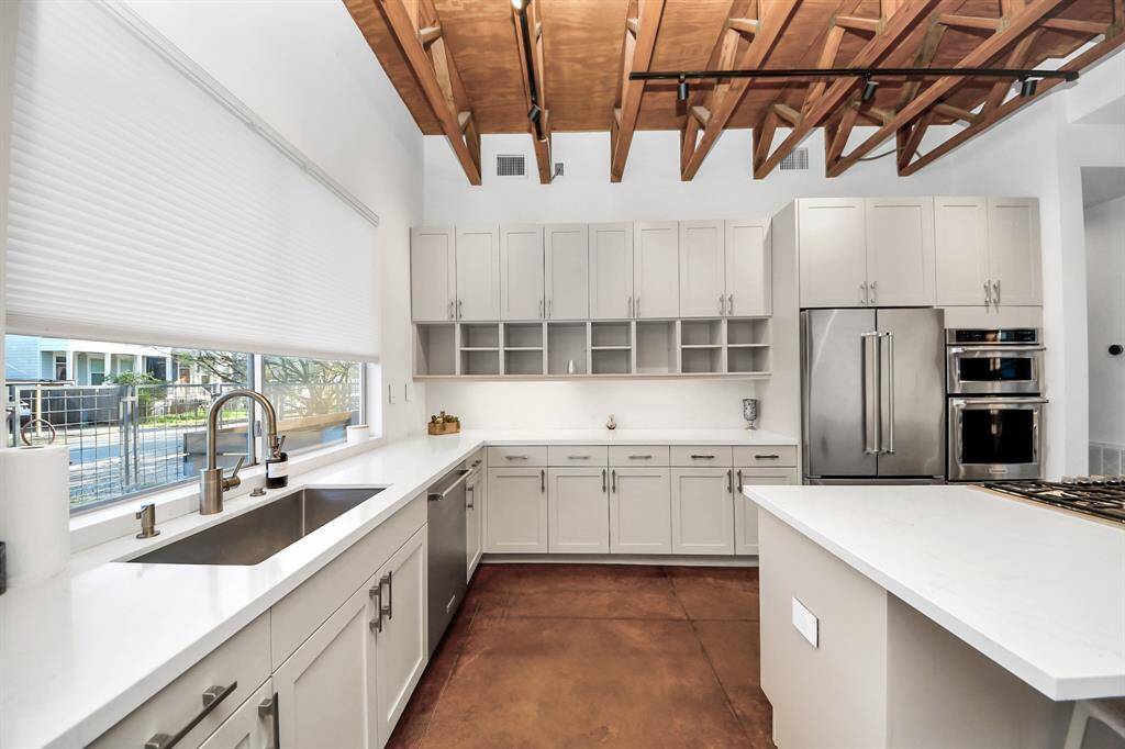 Large window in kitchen overlooks the side fenced yard.