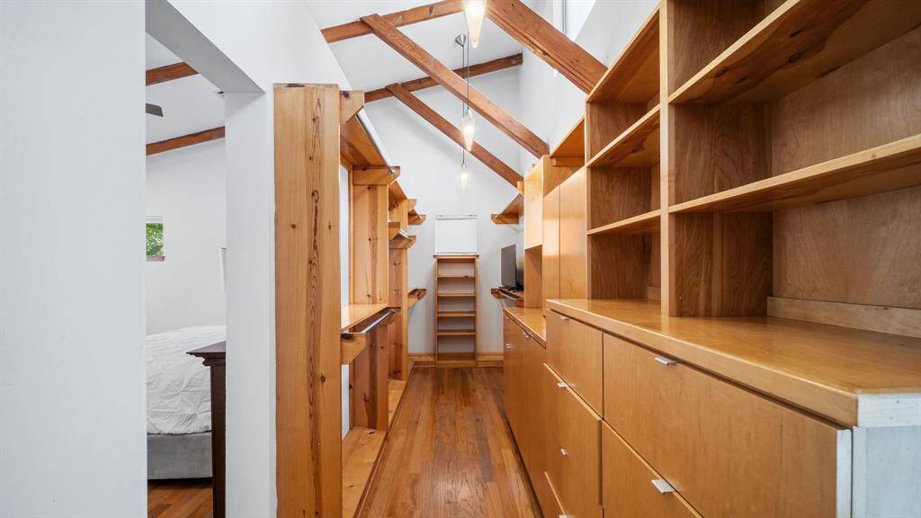 Large walk-in closet with built-ins is located behind the primary bedroom wall.