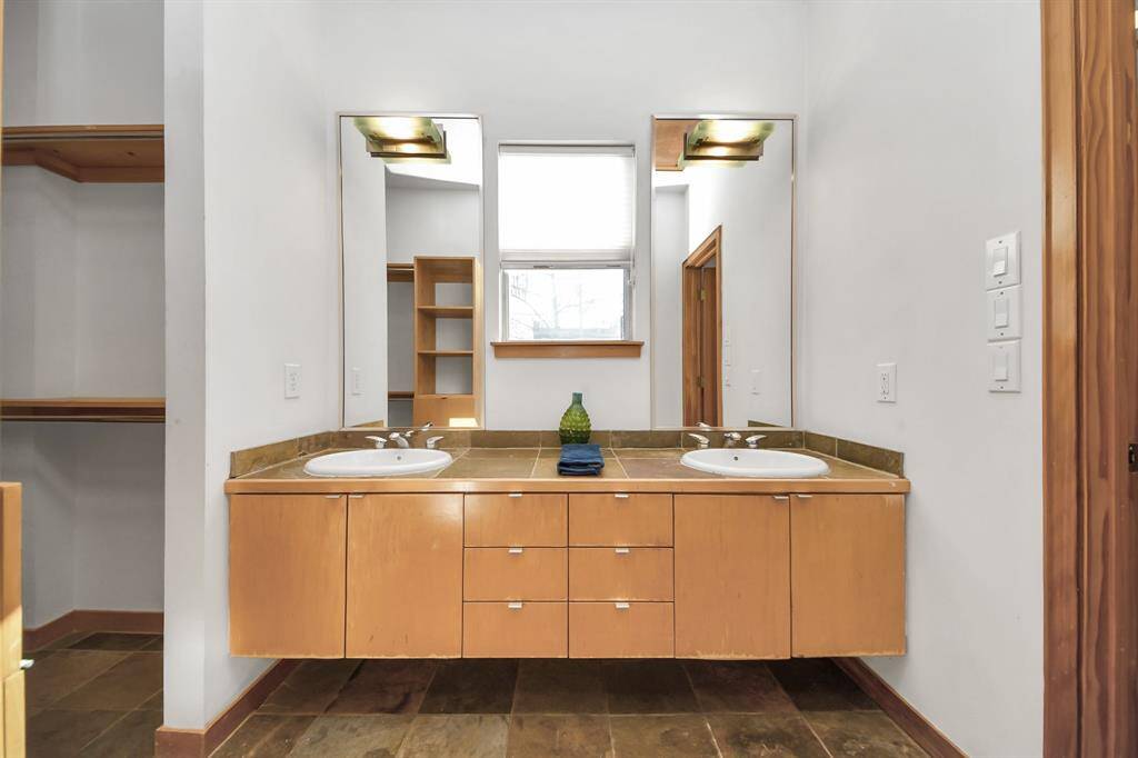 Double sinks divide walk-in closet and shower/tub toilet area