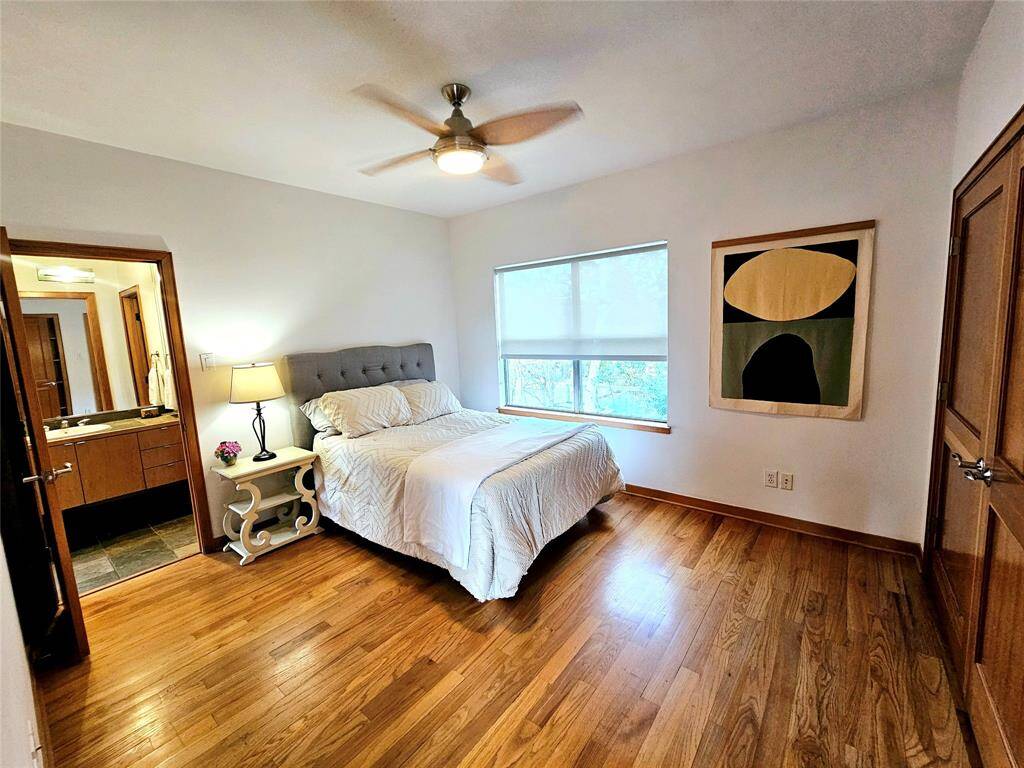 secondary bedroom located upstairs has double door closet with built-ins. The large window overlooks the back of the home, and is connected to a full bathroom with shower/tub combo