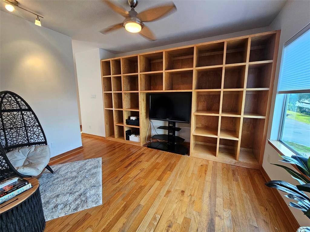 Open shelves in game room/flex space, with track lighting ready to showcase artwork on the wall