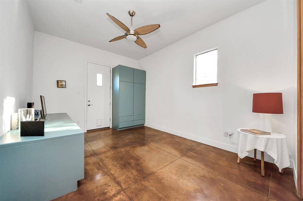 Secondary room on the first floor is currently used as an office and workout area, with built in cabinets and desk.  Side door provides access to fully fenced side yard and connects to full bathroom.