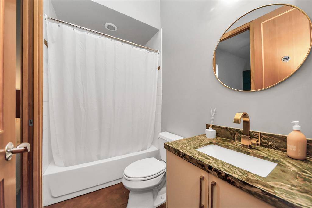 Full bath on 1st floor has direct access into bedroom/office and hallway for guest use.