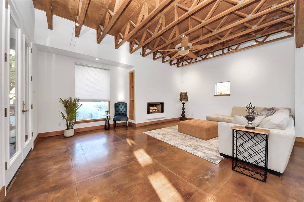Large open living area with gas fireplace overlooks the private courtyard. Track lighting throughout living, dining, and kitchen