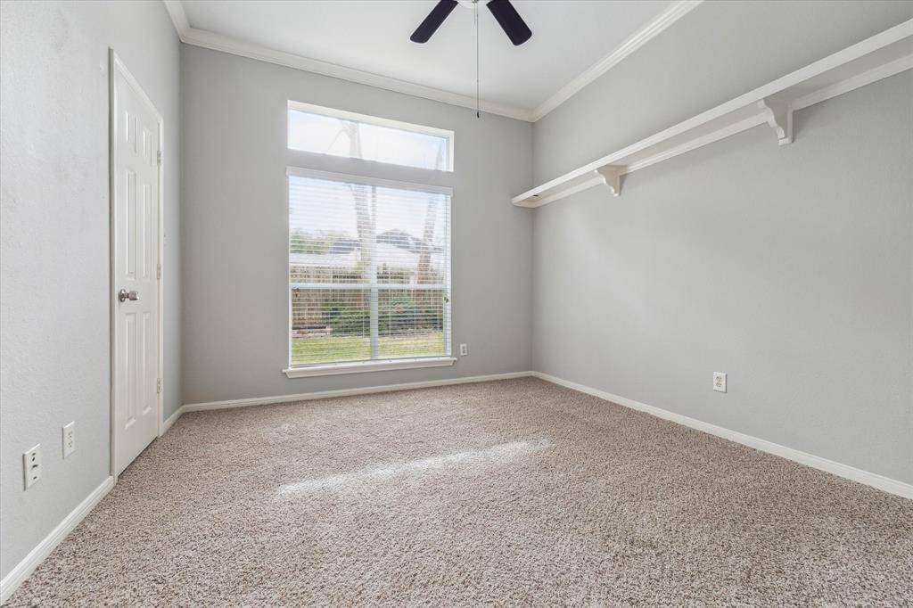 Secondary Bedroom faces the back of the home, features carpet and two closets.