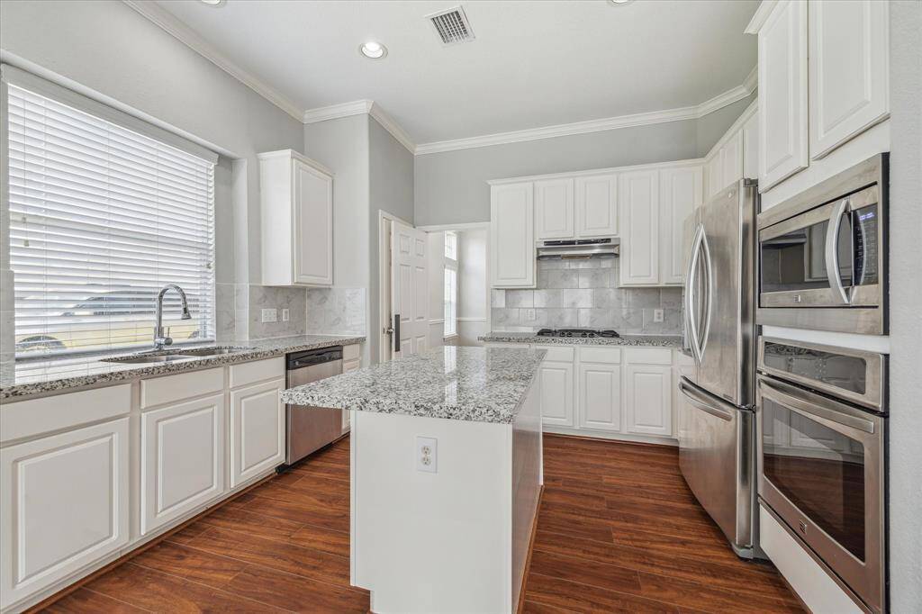A Chef's dream! This completely updated gourmet kitchen features granite countertops, a large island perfect for entertaining, stainless steel appliances & tons of counterspace. Fridge STAYS!
