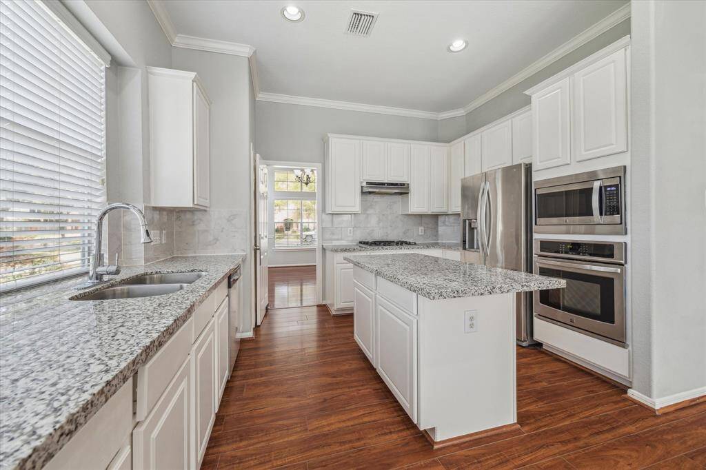 Modern aesthetics are found throughout the home with white cabinets.