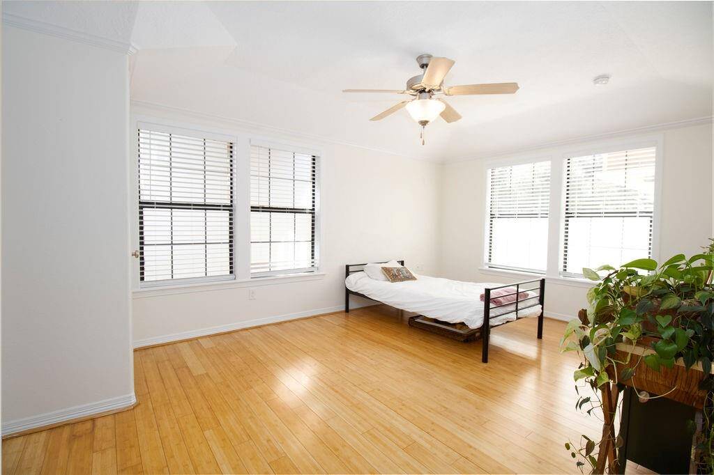 Downstairs Second Bedroom, Bright and airy  with large windows, LVP flooring, and a ceiling fan.
