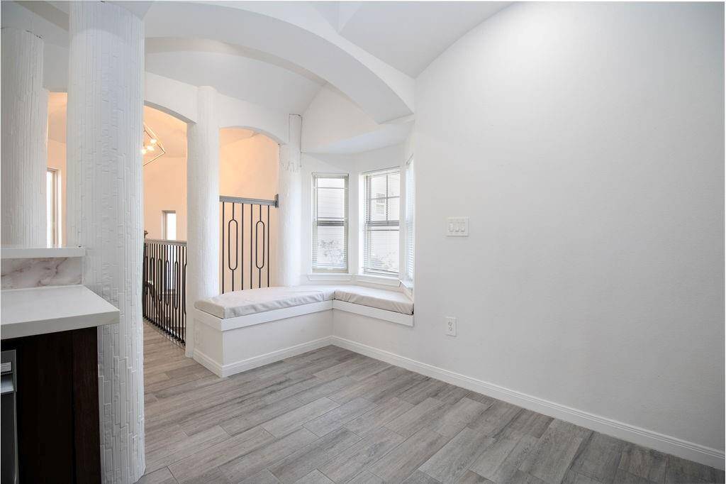 This photo showcases a bright, airy nook with a cozy built-in window bench, archways, and stylish flooring. Ideal for relaxation or as a reading nook in the guest apartment
