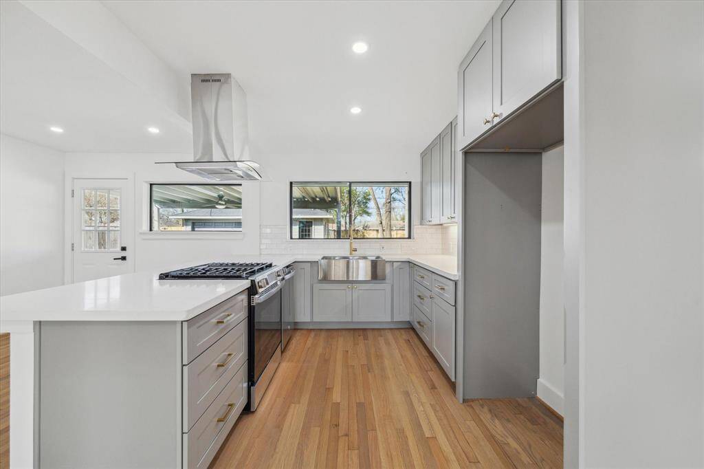 Bright and spacious living area opens to a sleek kitchen with ample natural light. Clean lines and neutral tones create a welcoming atmosphere.