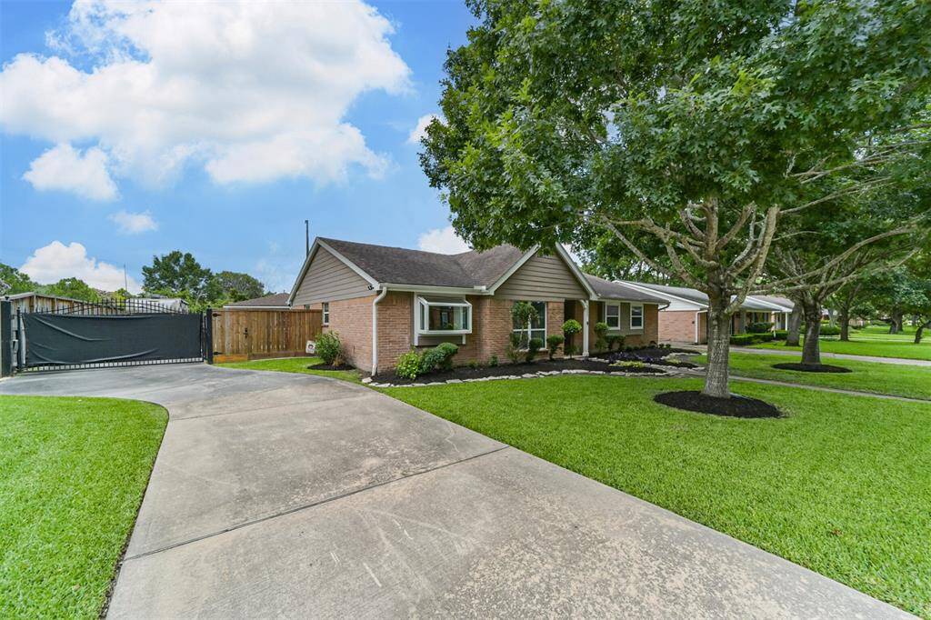 A curved driveway leads to a gated entrance, offering privacy and convenience. The exterior is inviting, with a landscaped walkway enhancing curb appeal.
