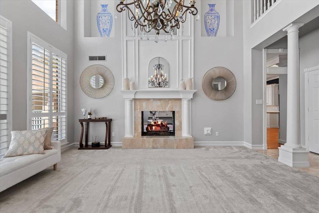 High ceilings, a classic 2-sided fireplace, and large windows with views of the pool area create an incredible entertaining space.