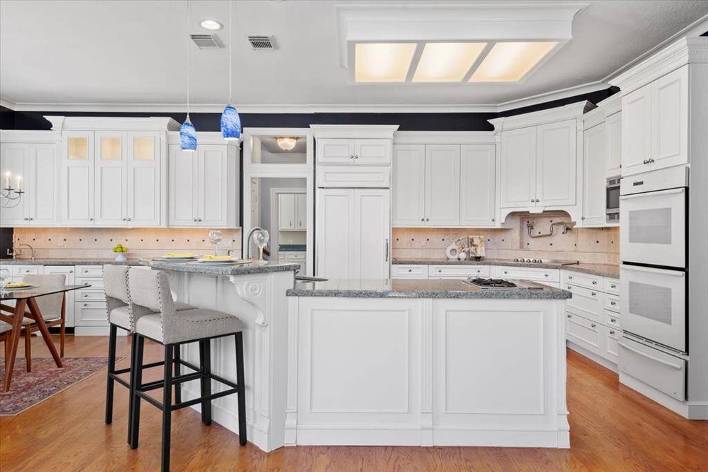 The appliances include a Sub Zero Refrigerator, an electric cooktop, a 2 burner gas cooktop,  a microwave and double ovens and a warming drawer.