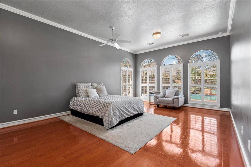 Primary bedroom is large and features arched windows with shutters.