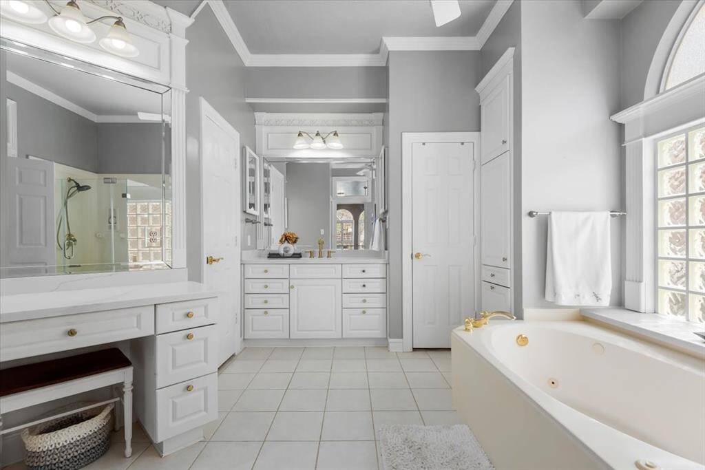 Primary bathroom has double sinks, a vanity area, whirlpool tub, and 2 closets!