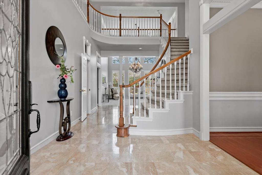 Incredible 2-story entry features a curved staircase and marble flooring.