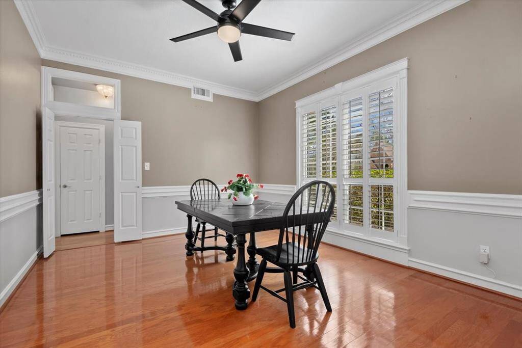 The elegant formal dining room features chair rail & crown molding plus beautiful plantation shutters.