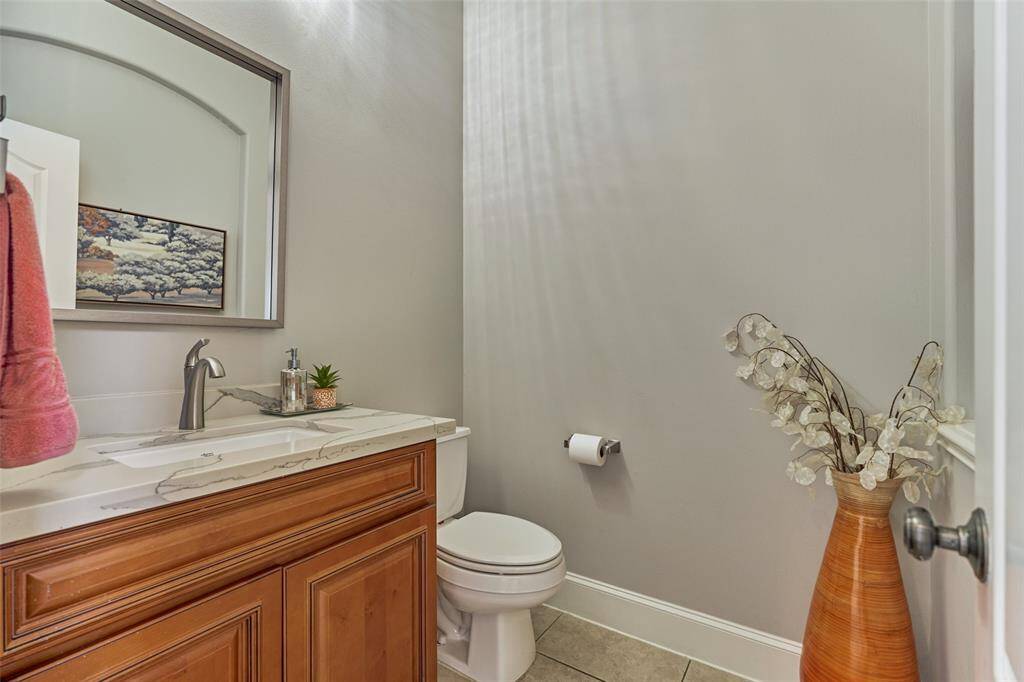 Elegant half bath featuring a sleek natural stone countertop.