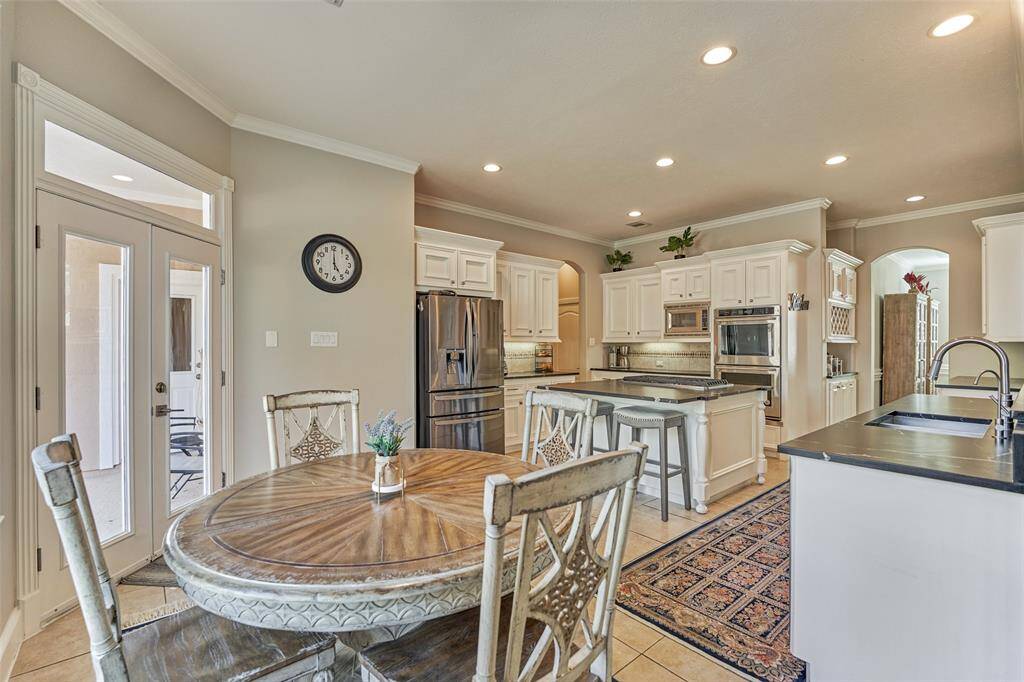 The breakfast room is vibrant and filled with natural light from stunning windows, offering beautiful views of the resort-style backyard.