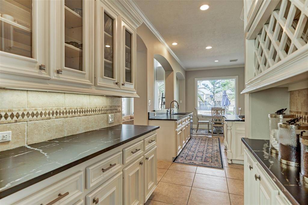 This Butler's Pantry seamlessly connects the dining room and kitchen, featuring custom cabinetry, undercabinet lighting, and ample counter space—perfect for entertaining.
