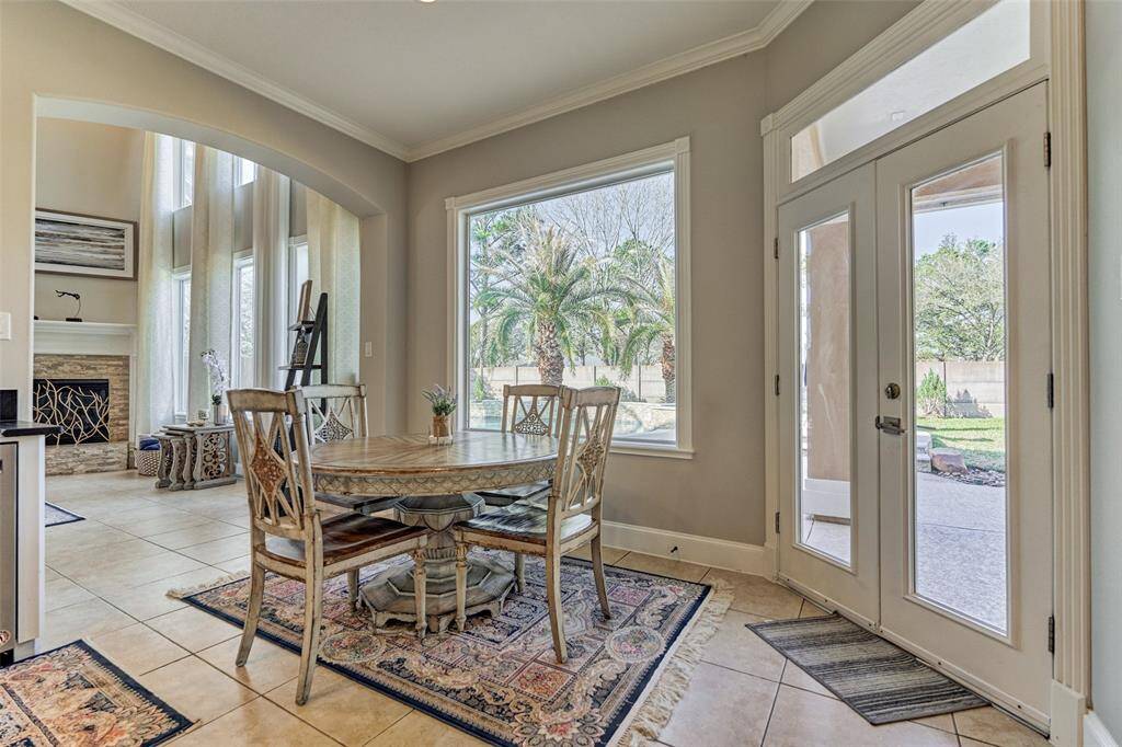Enjoy stunning views of the backyard, kitchen, and living area from this cozy breakfast room.