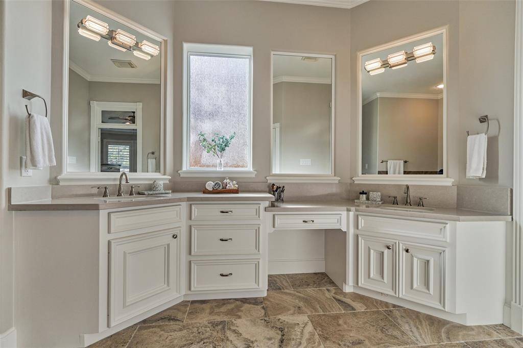 Elegant double vanity with abundant lighting and stylish framed mirrors.