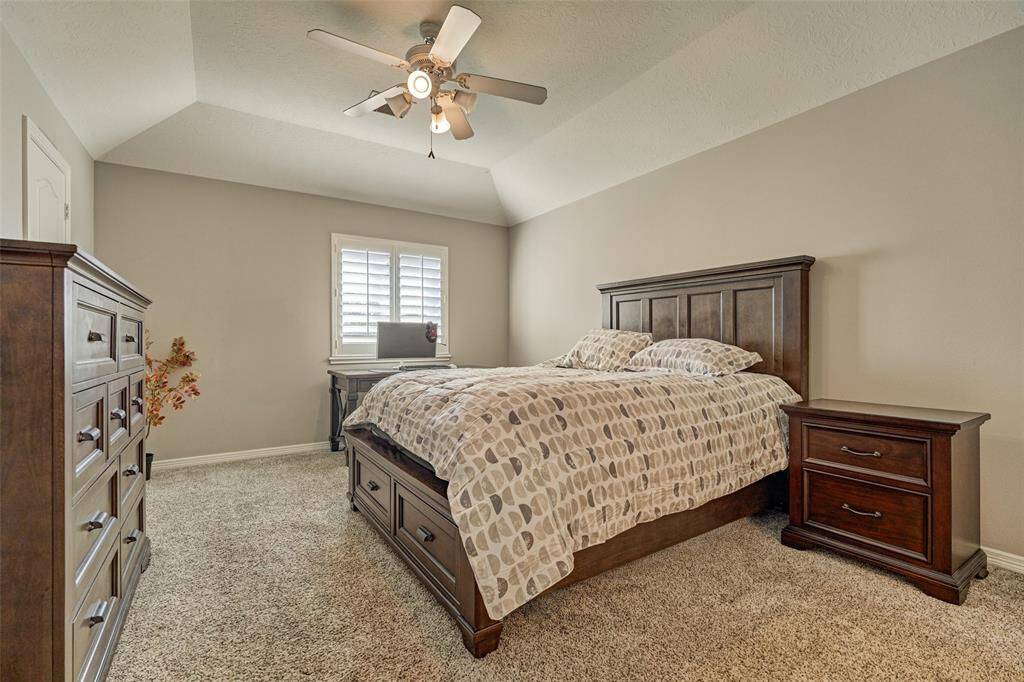 Upstairs third bedroom featuring elegant plantation shutters.