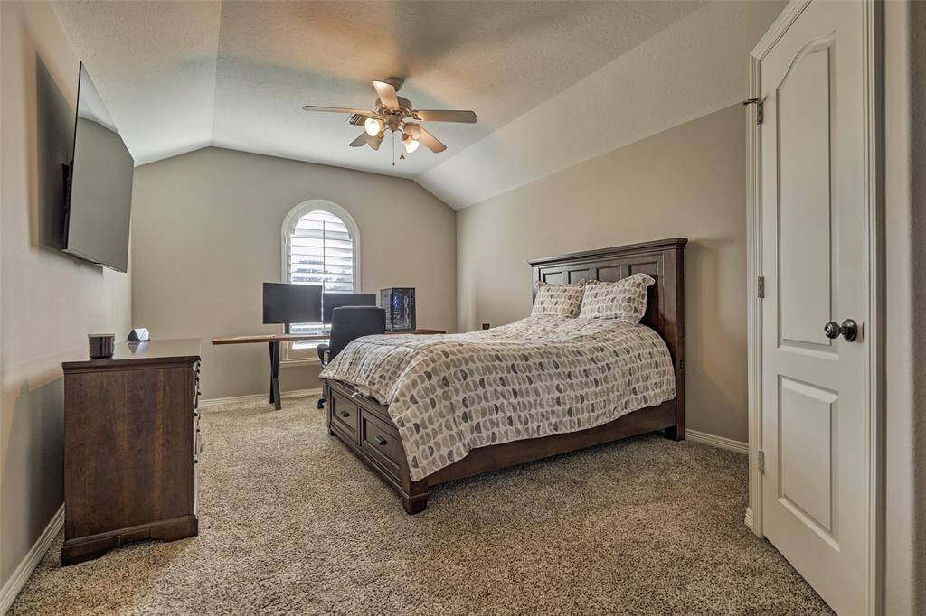 Spacious upstairs fourth bedroom with elegant plantation shutters.