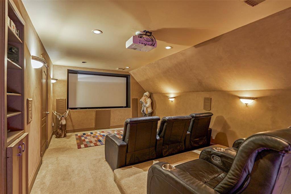 Experience cinematic luxury in this cozy movie room, featuring ambient lighting, six recliners, and a large projector for unforgettable movie nights and sports events.