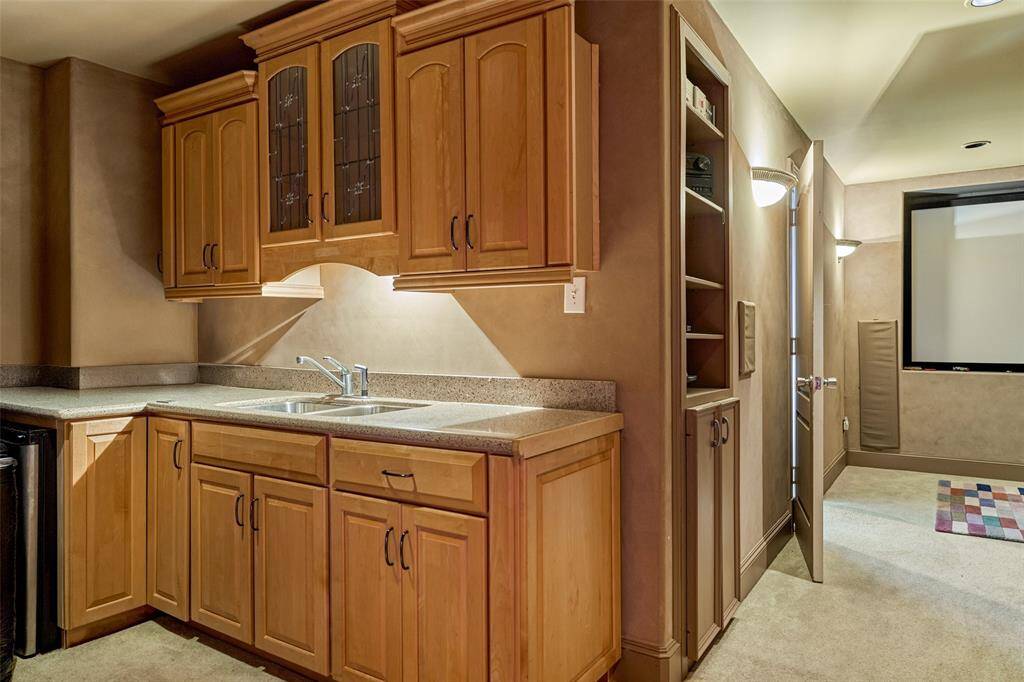 Luxurious wet bar in the movie room, featuring custom cabinetry and ample counter space.