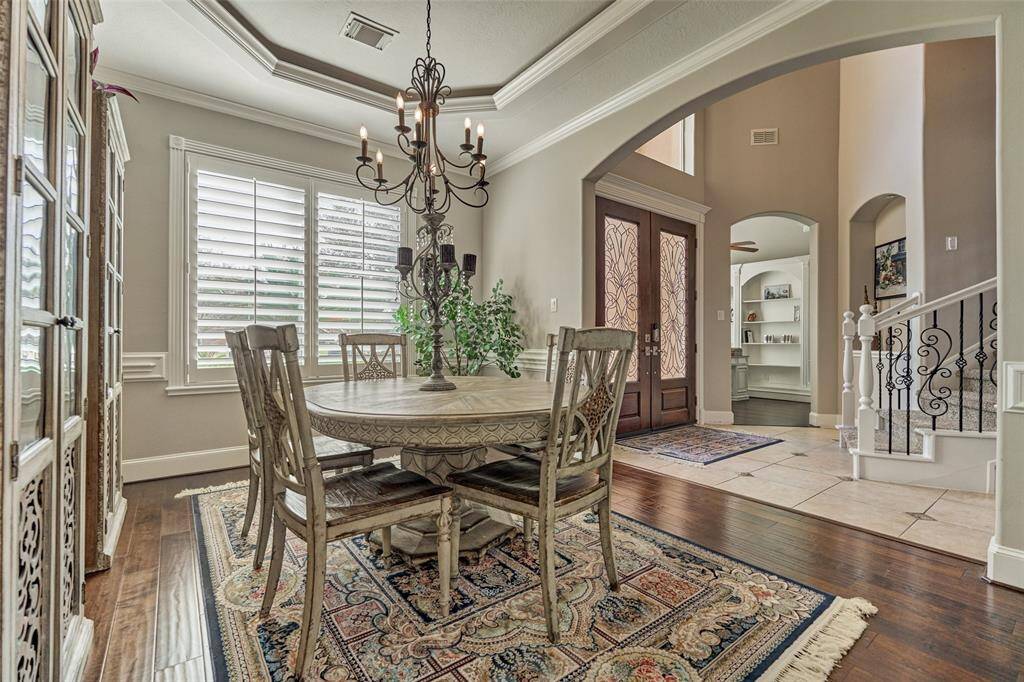 Discover the elegant formal dining room at the front of the home, featuring cove lighting and abundant natural light.