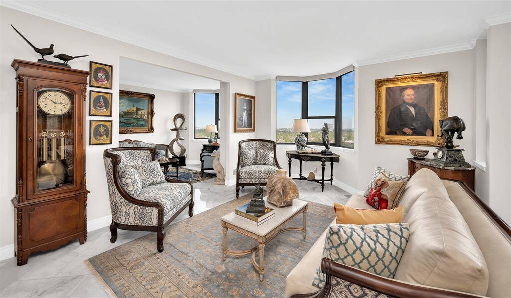 View of the living area looking into the opened second bedroom, perfect as a den or study. Note the exquisite marble flooring throughout in a herringbone pattern.