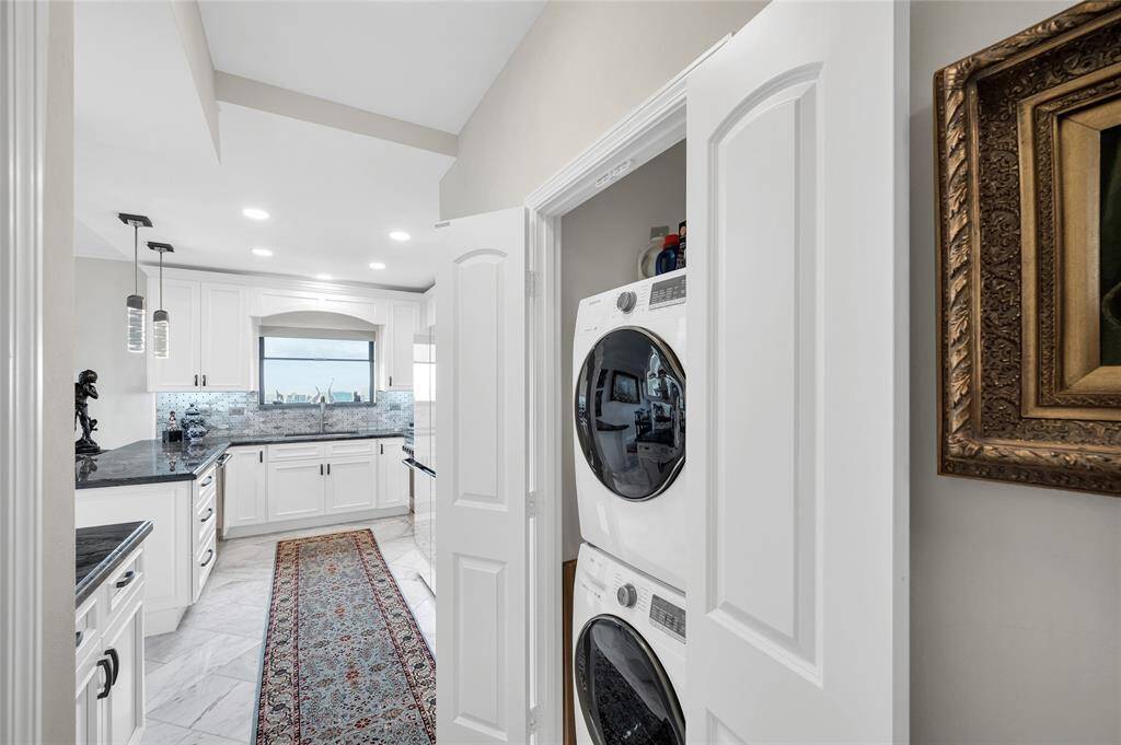 View of the custom kitchen with the reveal of the full size washer/dryer.