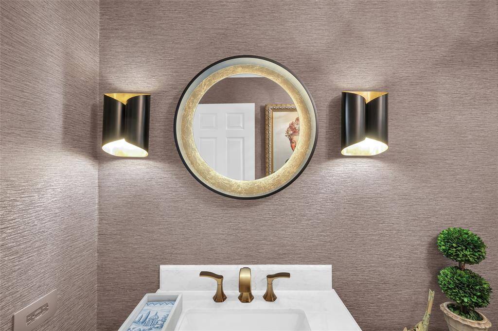 This stylish mirror and light fixtures adds a touch of luxury to the bathroom.