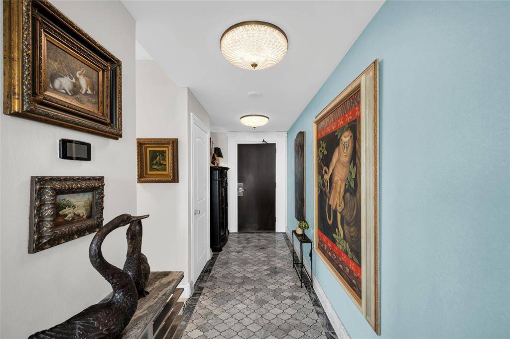 Two stunning Schonbek crystal ceiling light fixtures illuminate a gorgeous custom 14.5 foot marble mosaic entry floor, complemented by marble basboards.