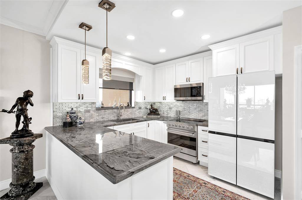 Well-appointed designer kitchen with Viking appliances, quartzite counter tops, and glass-front/5-door refrigerator.